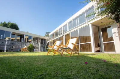 two chairs sitting in the grass in front of a building at Castelo Santa Catarina in Porto
