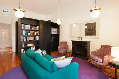 a living room with a blue couch and a fireplace at The A5 Smart Luxury Studios in Porto