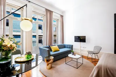 a living room with a blue couch and windows at The A5 Smart Luxury Studios in Porto