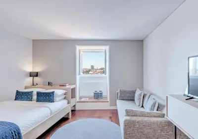 a living room with a couch and a bed and a window at Oporto Street das Aldas - River View in Porto