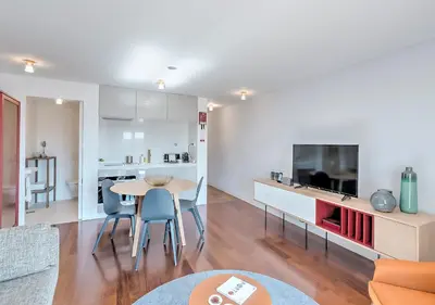 a kitchen and living room with a table and a tv at Oporto Street das Aldas - River View in Porto