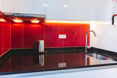 a kitchen with red walls and a sink at APOSENTUS - Your Home at Pinheiro's Studio in Porto