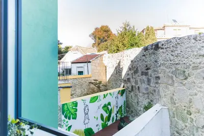 a view from a window of a stone wall at APOSENTUS - Your Home at Pinheiro's Studio in Porto