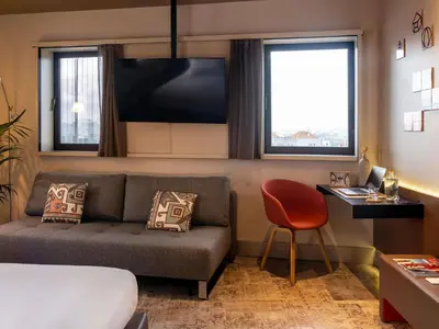 a bedroom with a bed and a table and chairs at Mercure Porto Centro Santa Catarina in Porto