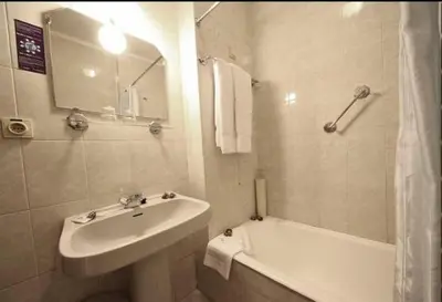 a white bathroom with a sink and a bath tub at Hotel Palanca in Porto