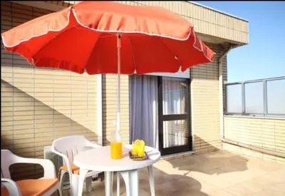 a table with a red umbrella on a patio at Hotel Palanca in Porto