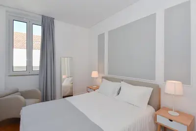 a white bedroom with a bed and a couch at Oporto Lovely House in Porto
