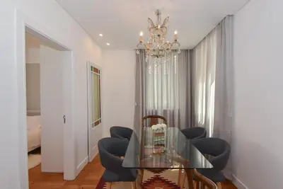a dining room with a glass table and blue chairs at Oporto Lovely House in Porto