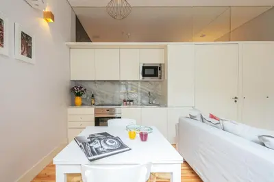 a living room with a white table and a white couch at Indulge Porto Flats in Porto
