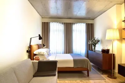 a hotel room with a bed and a couch at My Story Apartments Porto - Santa Catarina in Porto