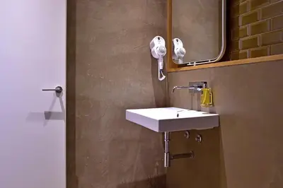 a bathroom with a white sink and a mirror at My Story Apartments Porto - Santa Catarina in Porto