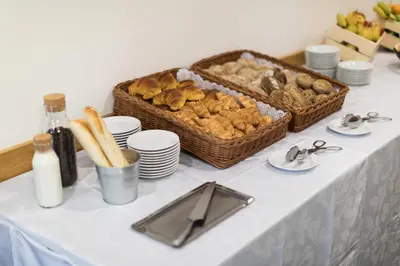 a table with a basket of bread and a basket of pastries at Legendary Porto Hotel in Porto