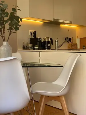 a white chair sitting next to a glass table in a kitchen at Magalhães Prime in Porto