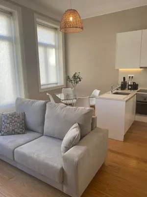 a living room with a couch and a kitchen at Magalhães Prime in Porto