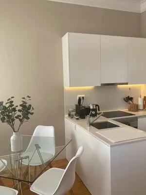 a kitchen with a glass table and white cabinets at Magalhães Prime in Porto
