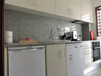 a kitchen with white cabinets and a white dishwasher at Art Gallery Apartment in Porto