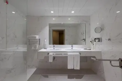 a white bathroom with two sinks and a mirror at Portus Cale Hotel in Porto