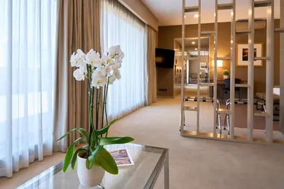 a living room with a glass table with a vase of flowers at Portus Cale Hotel in Porto