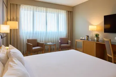 a hotel room with a bed and a desk and chairs at Portus Cale Hotel in Porto