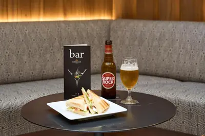 a table with a sandwich and a bottle of beer at Portus Cale Hotel in Porto
