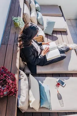 a woman laying on a table reading a book at Boavista Guest House in Porto