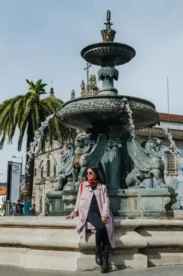 a woman sitting in front of a fountain at Boavista Guest House in Porto