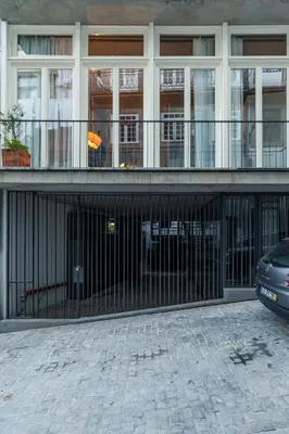 a building with a black gate in front of a building at Villa Lóios by Casa do Conto in Porto