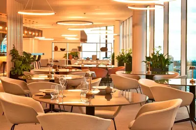 a restaurant with tables and chairs and windows at Porto Palácio Hotel by The Editory in Porto