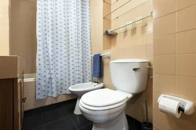 a bathroom with a toilet and a blue shower curtain at LV Premier Marques MQ2 in Porto