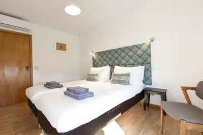 a bedroom with a large white bed with a headboard at LV Premier Marques MQ2 in Porto