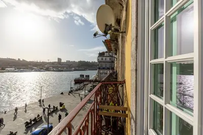 a balcony of a building with a view of the water at YOUROPO - Ribeira Porto in Porto