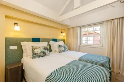a bedroom with a large white bed with a window at YOUROPO - Ribeira Porto in Porto