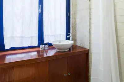 a bathroom with a white sink on a wooden counter at Flores Studio in Porto