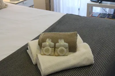 a bed with white towels and flowers on it at Flores Central in Porto