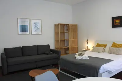 a living room with a bed and a couch at Flores Central in Porto