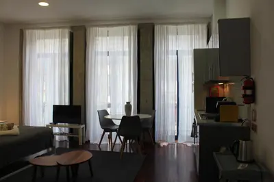 a room with a bed and a table with chairs at Flores Central in Porto