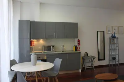 a kitchen with a white table and a table and chairs at Flores Central in Porto