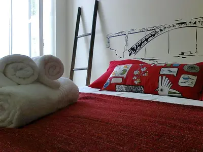 a bedroom with a bed with a red blanket and a bed frame at Formosa Oporto Apartments Group in Porto