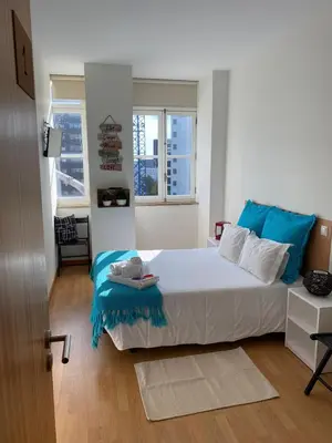 a bedroom with a bed with a blue blanket on it at Formosa Oporto Apartments Group in Porto