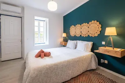 a bedroom with a bed with a teddy bear on it at Ren Feb26 Clerigos Retreat in Porto