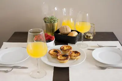 a table with plates of food and glasses of orange juice at Gil Vicente - Charming Guesthouse in Porto