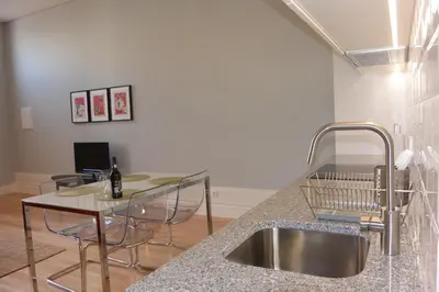 a kitchen with a sink and a counter with a table at Casa Paillard, by Flat in Porto in Porto