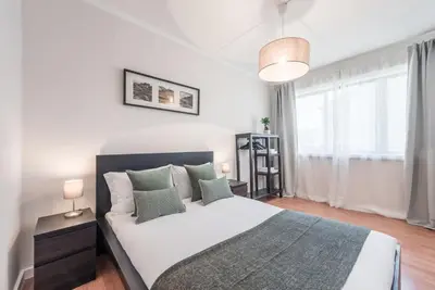 a bedroom with a bed and a large window at GuestReady - Terracota Bureau in Porto