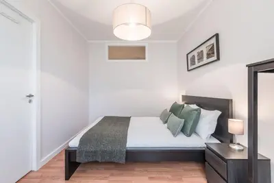 a white bedroom with a bed with green pillows at GuestReady - Terracota Bureau in Porto