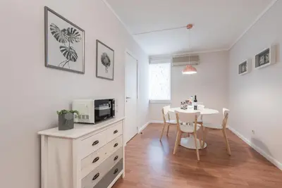 a white kitchen with a table and a microwave at GuestReady - Terracota Bureau in Porto