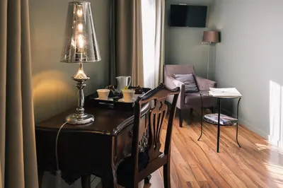 a desk with a lamp and a chair in a room at Hotel Sao Jose in Porto
