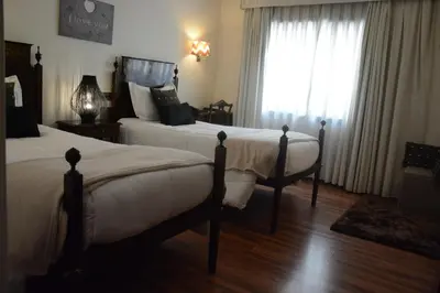 a bedroom with two beds and a window at Hotel Sao Jose in Porto