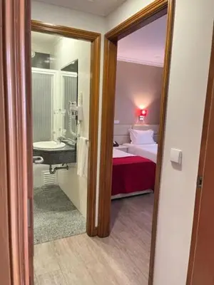 a room with a bedroom with a bed and a mirror at Seculo Hotel in Porto