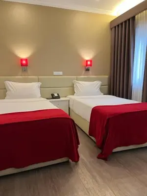two beds in a hotel room with red lamps at Seculo Hotel in Porto