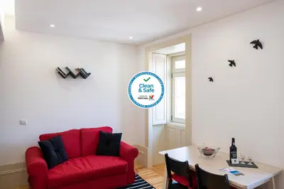 a living room with a red couch and a table at Lively Getaway Apartment in Porto